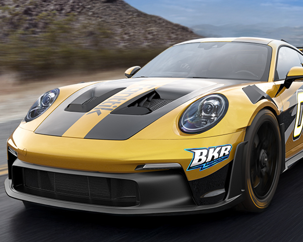 Żółto-czarny sportowy samochód jadący z dużą prędkością widziany od przodu