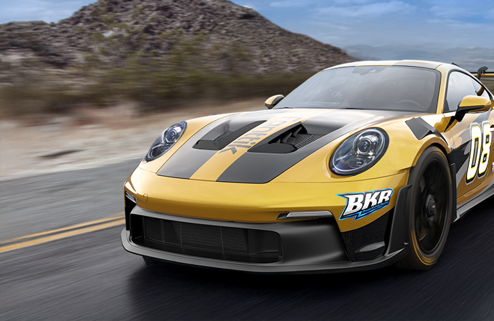 Żółto-czarny sportowy samochód jadący z dużą prędkością widziany od przodu