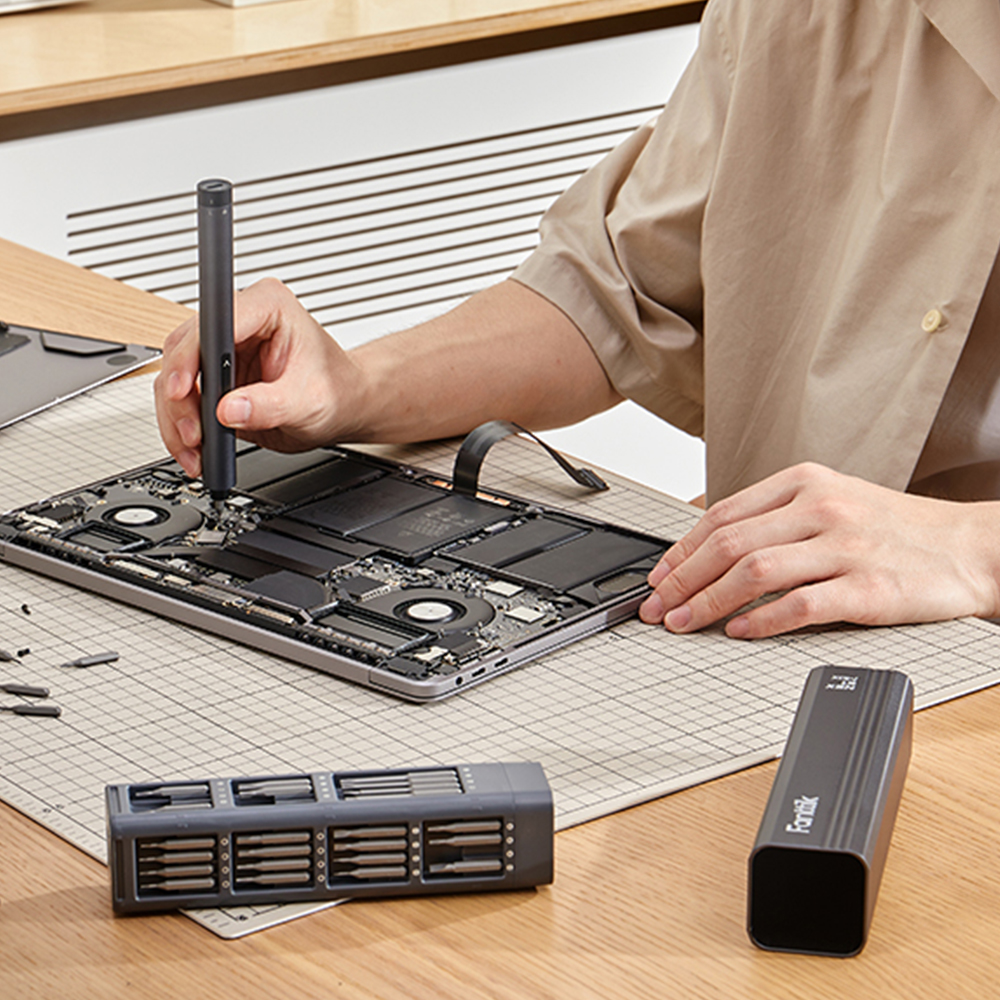 Osoba pracująca przy rozebranym laptopie wkrętakiem E1 MAX