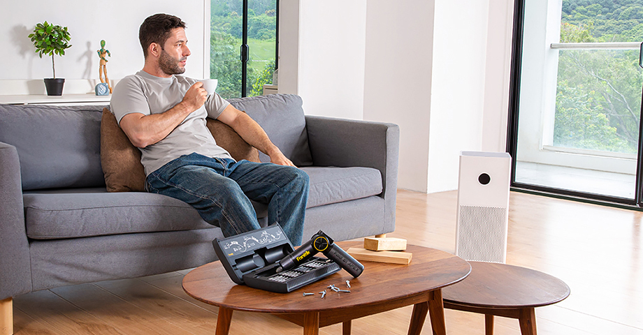 Mężczyzna odpoczywający z kawą na kanapie, z przodu, na stole leży wkrętak Fold S1 APEX w etui