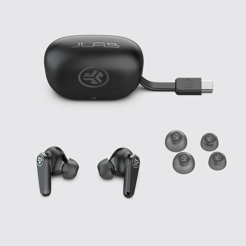 Etui ładujące, słuchawki JLab Go Pods ANC i dwie pary gumek ułożone obok siebie.