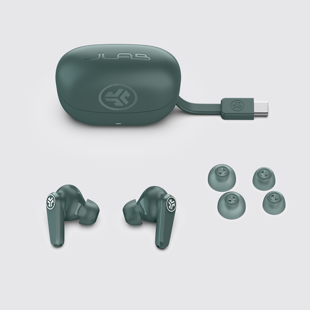 Etui ładujące, słuchawki JLab Go Pods ANC i dwie pary gumek ułożone obok siebie.