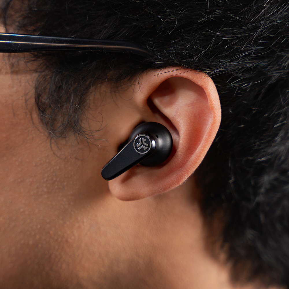 Zbliżenie na słuchawkę JLab Go Pods ANC w uchu mężczyzny.
