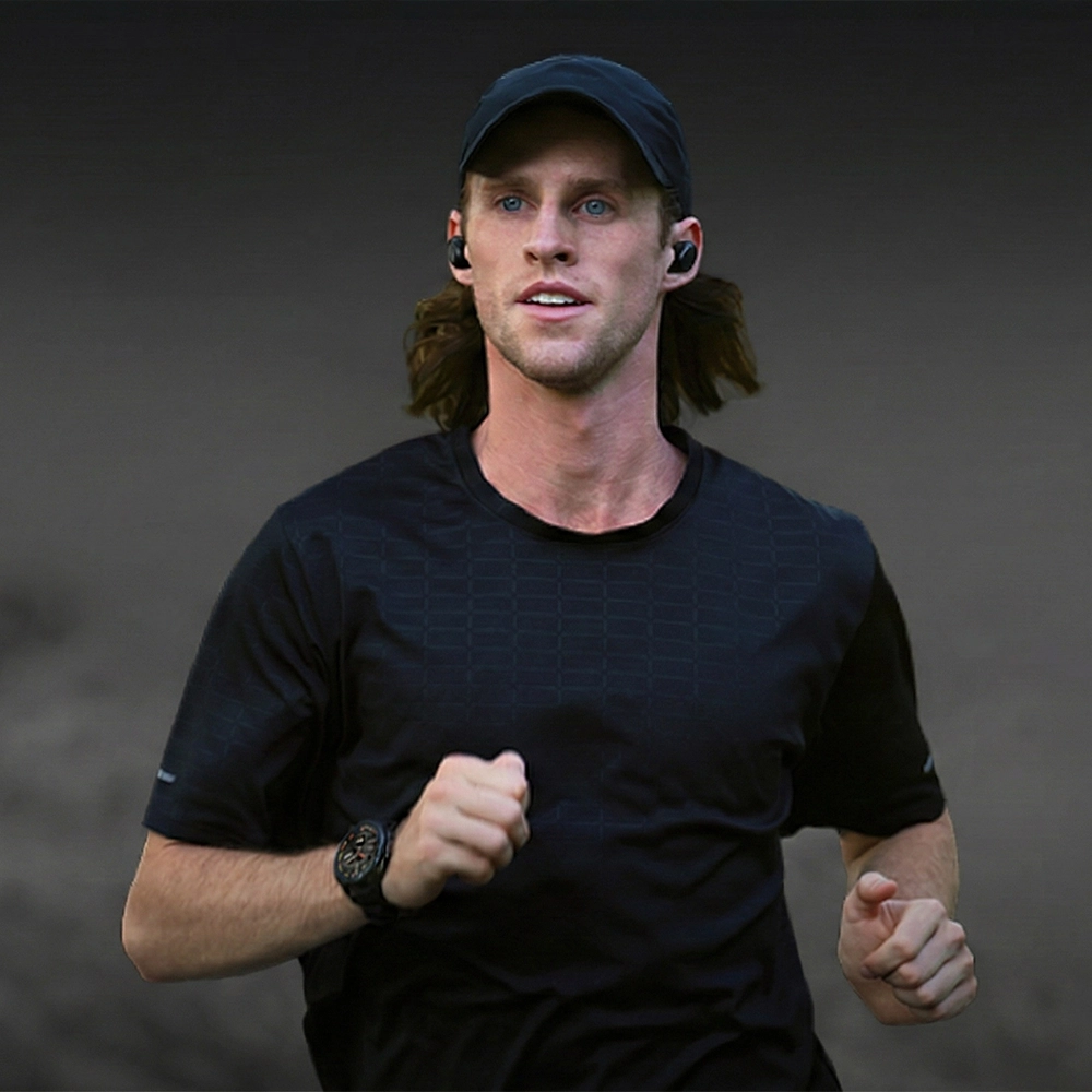 Zbliżenie na mężczyznę w sportowym ubraniu biegnącego w słuchawkach i ze smartwatchem Kospet Tank T4 na nadgarstku.