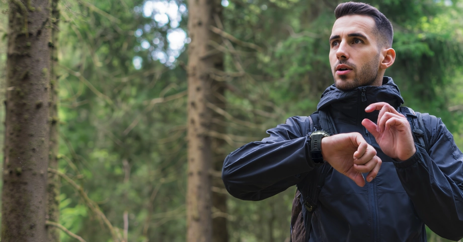 Mężczyzna w lesie korzystający ze smartwatcha Kospet Tank T4, który ma na nadgarstku.