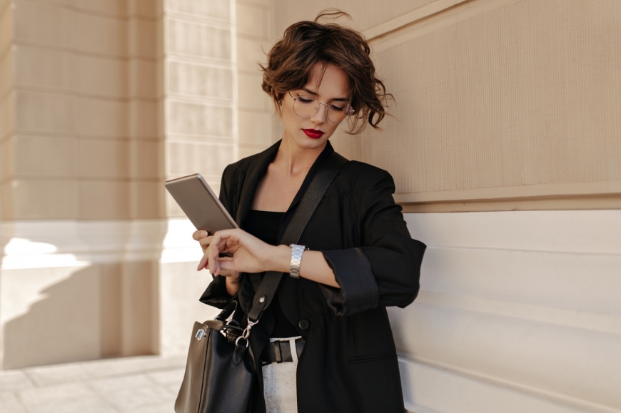 Elegancko ubrana kobieta sprawdza czas na smartwatchu